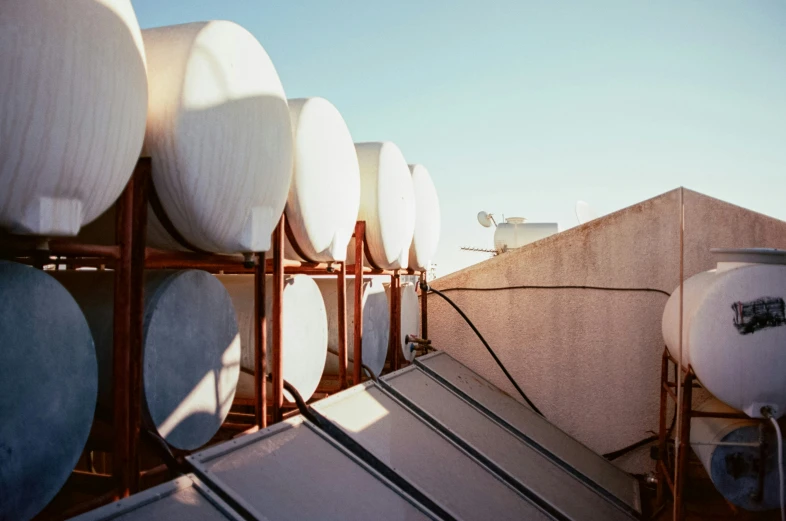 white water tanks lined up on a rooftop