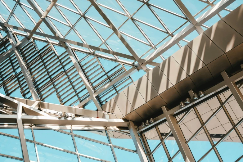 the inside of a building with metal beams and glass walls