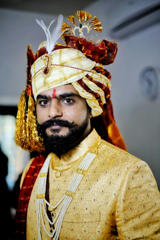 a man is dressed in a golden outfit and a turban