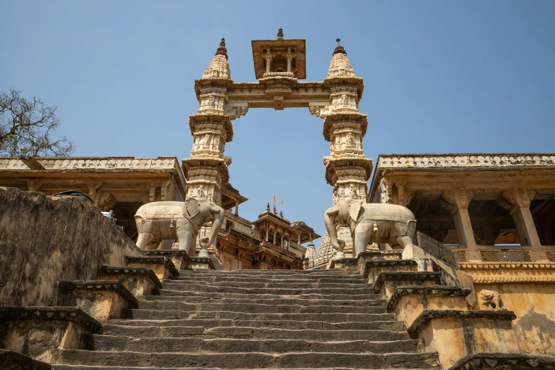 the tall statue of elephant sitting in front of the stairs