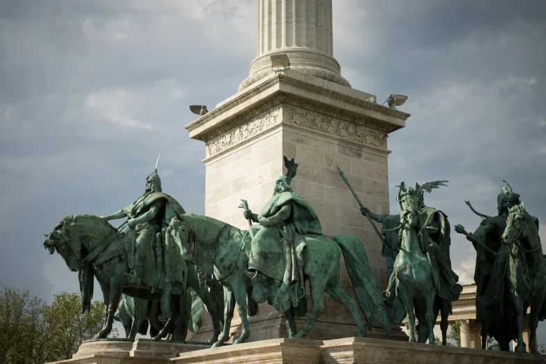 a group of horses statue next to a tall white building