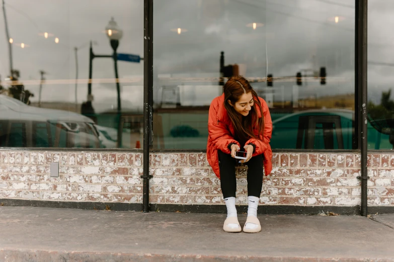 a woman sitting in front of a store window