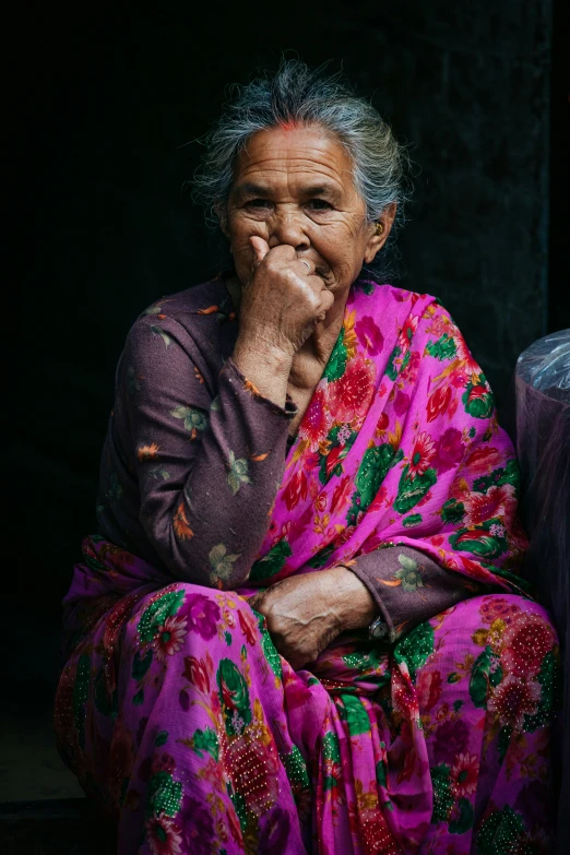 the old woman in pink sits down in the dark