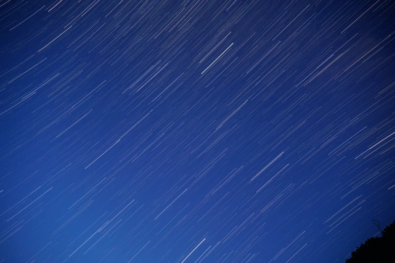 a blue sky full of stars with an airplane flying