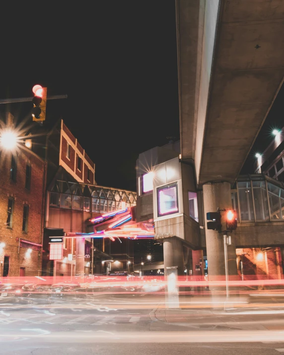 the night traffic is seen under a bridge in the city