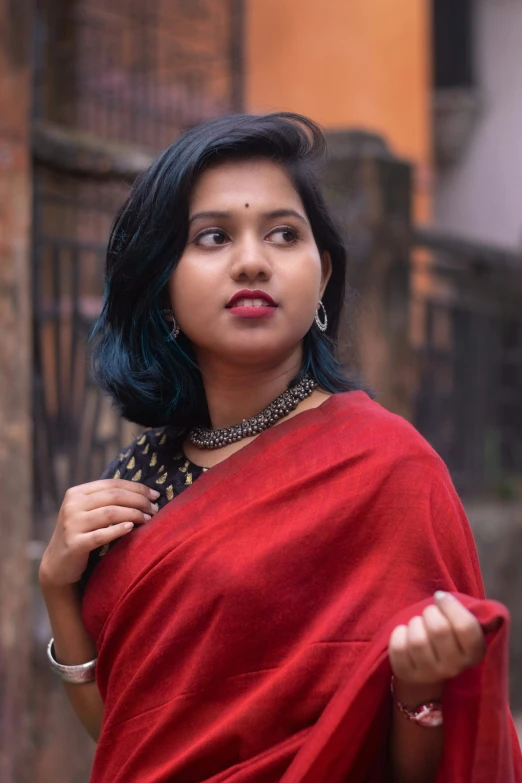 an indian woman wearing a red dress posing for a pograph