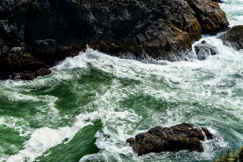 waves crash against rocks along the shore line