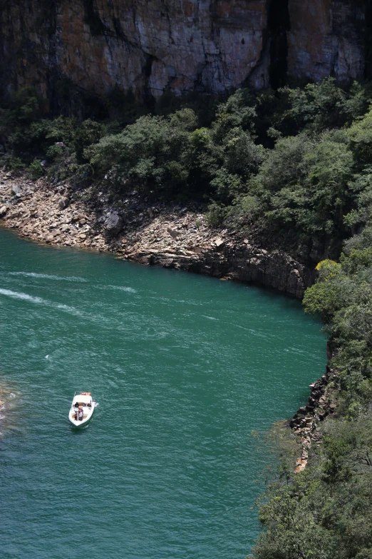 a boat traveling along the side of a river