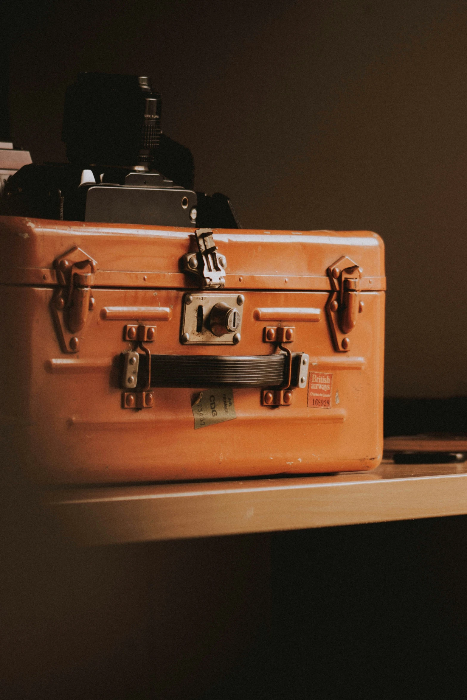 a brown suit case on top of a wooden desk