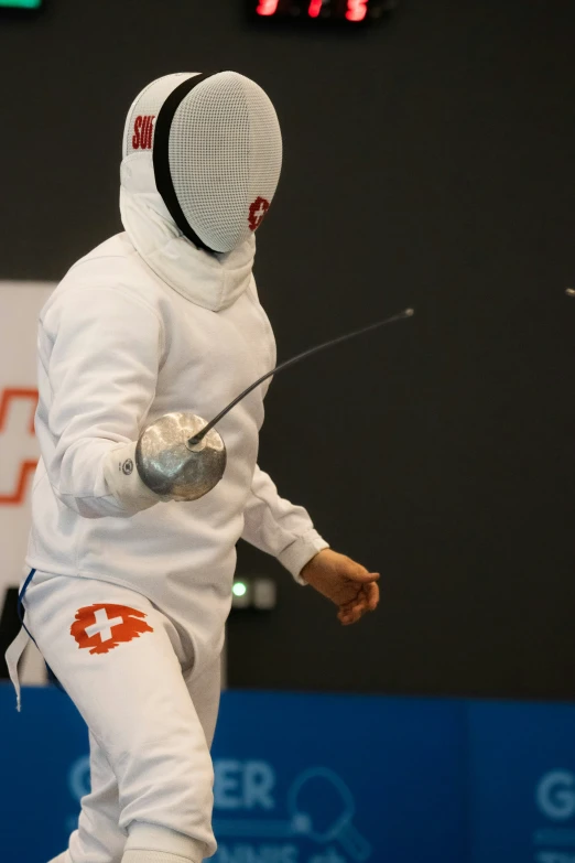 the man is fencing while holding his racket