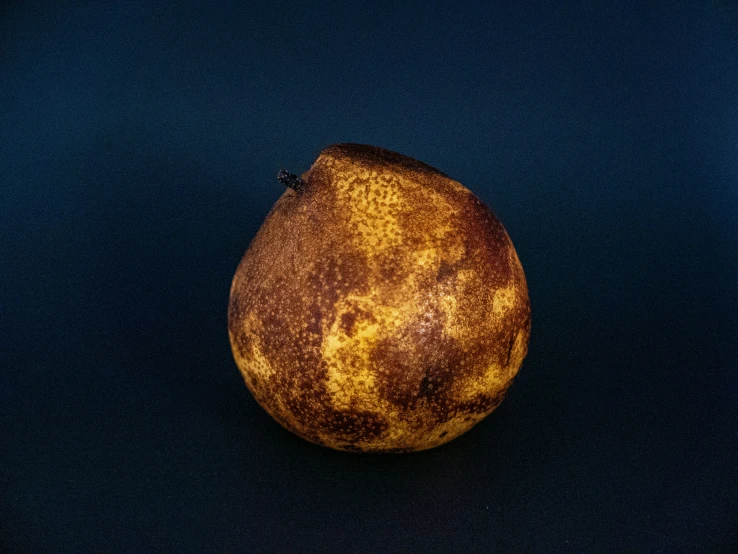 an orange sitting on top of a dark surface