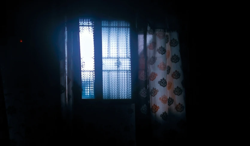 a window is illuminated by a dark curtain