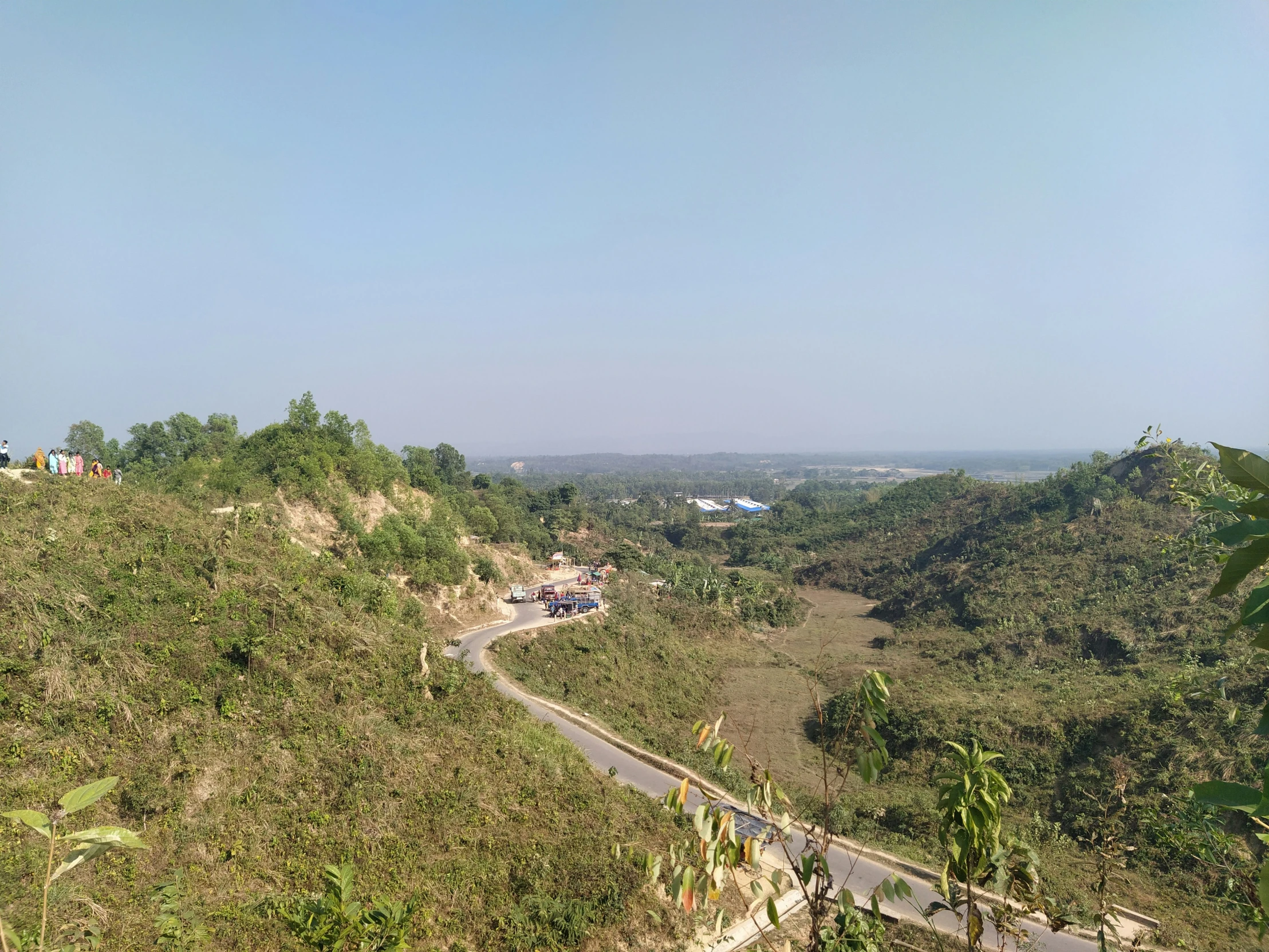 a car driving on a road near the top of a hill