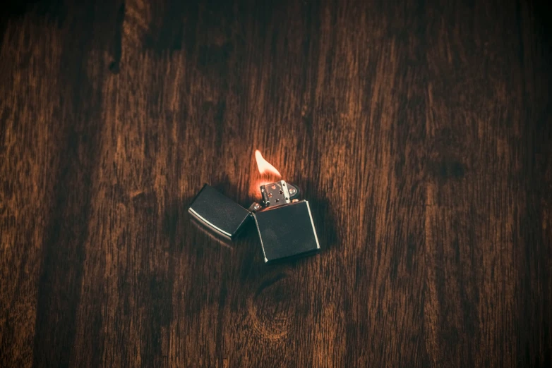 an open black cigarette sitting on top of a wooden table