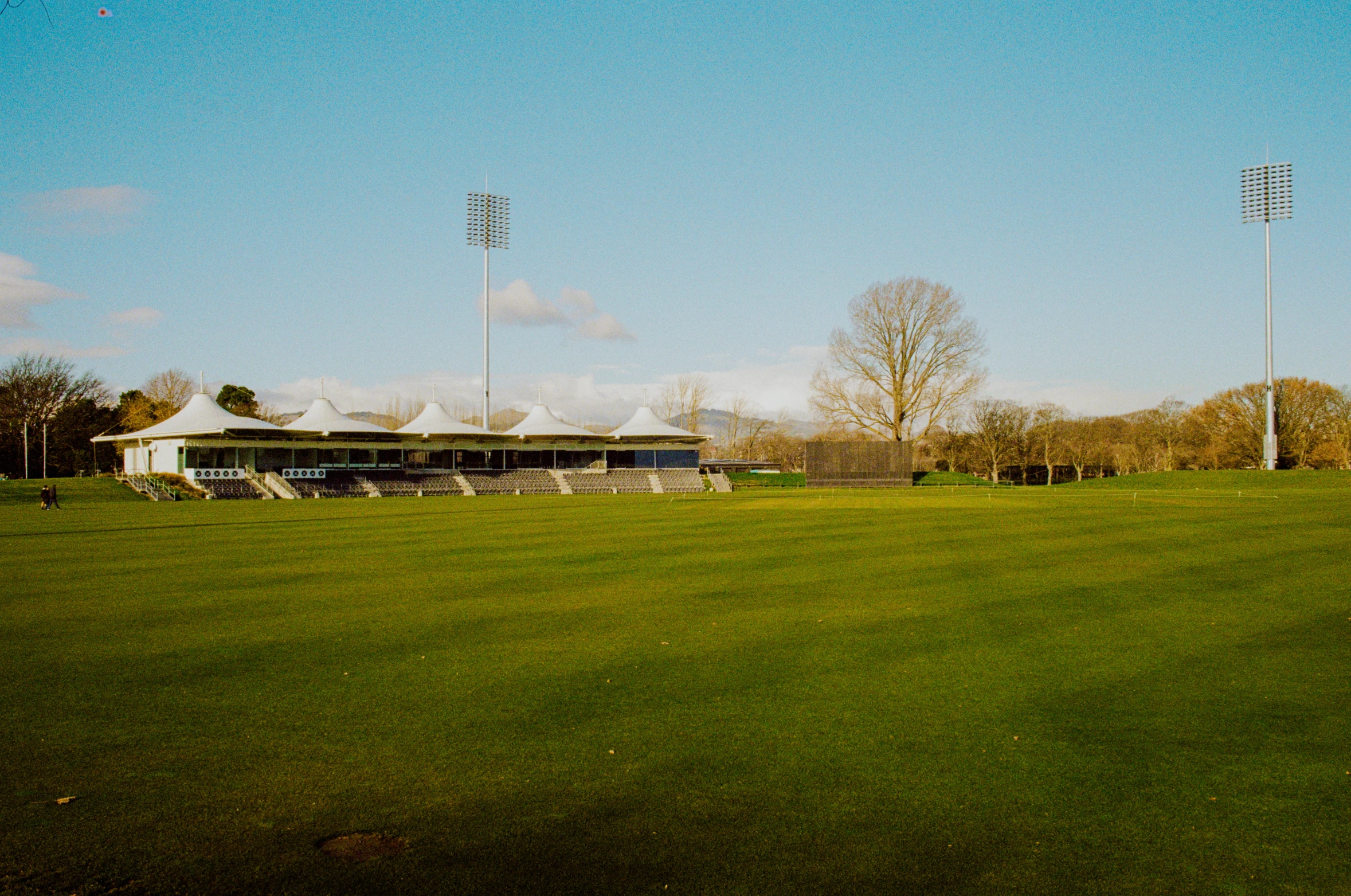 the grass is green and has a large building in the distance