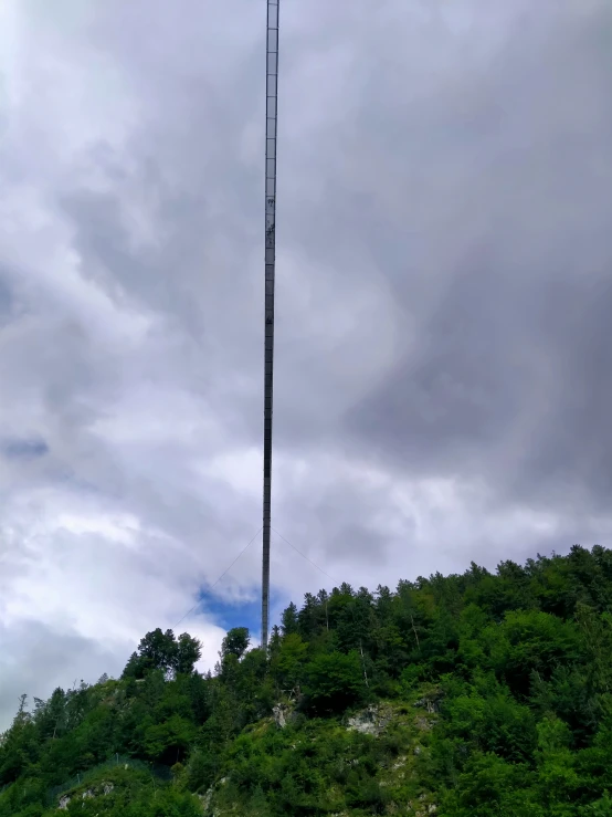 an antenna on a mountain with trees in the background