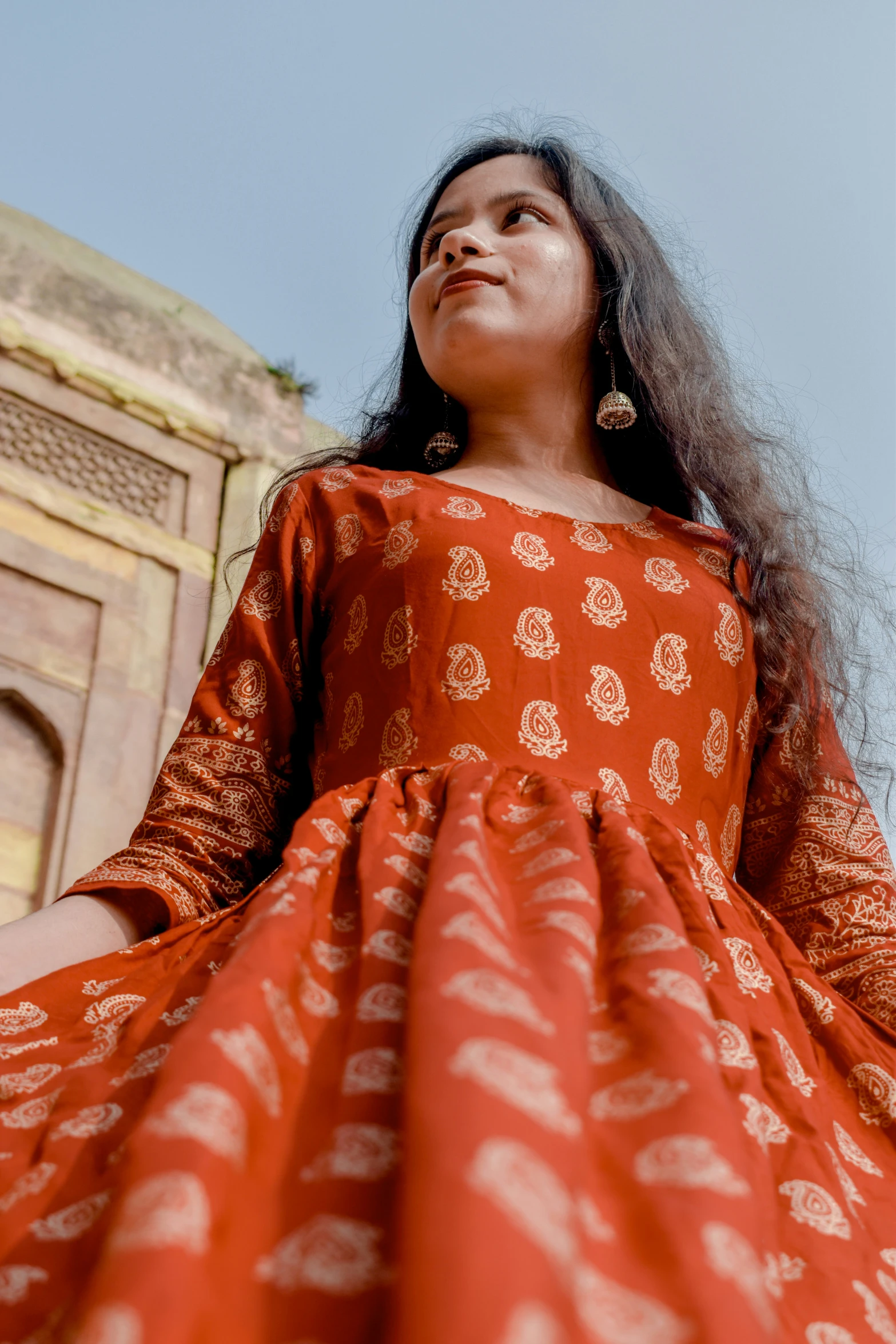 a woman with long hair in an orange dress