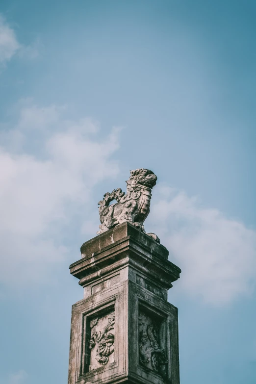 a tall statue on top of a brick pillar