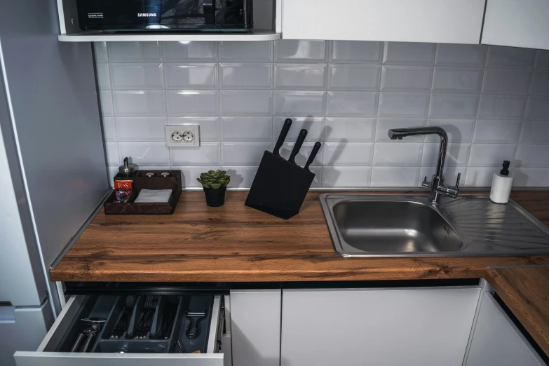 a kitchen counter that has several knives and other objects on it