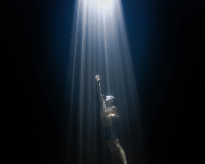 a woman standing under sunlight streaming through her body