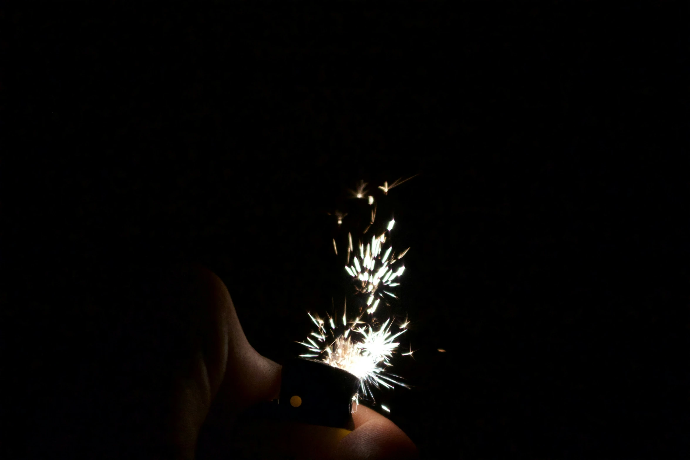 a person holding a cell phone and light up sparklers
