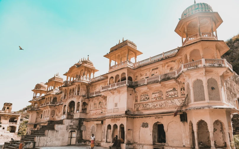 a building with carved designs and a bird flying in front