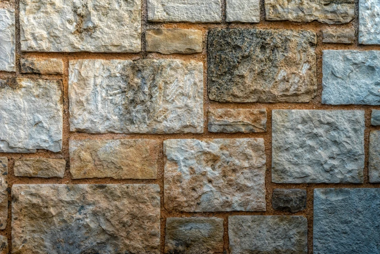 gray stones on brick wall with grass growing on it