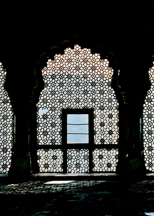 a decorative arch in the dark with a screen window