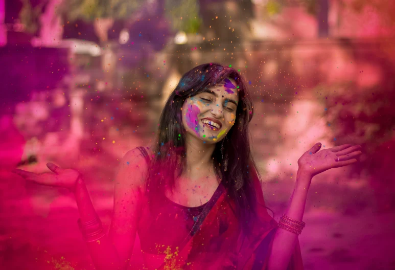 woman in bright colored powder posing for the camera