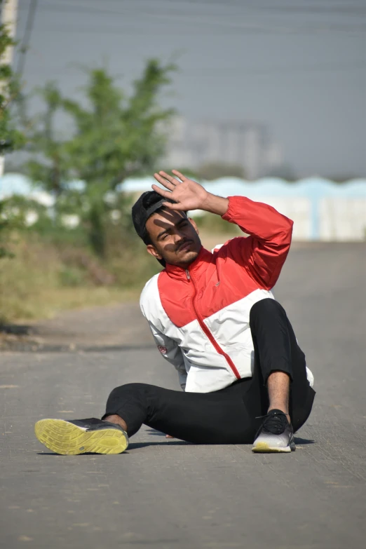 a man sitting on the road in front of the camera