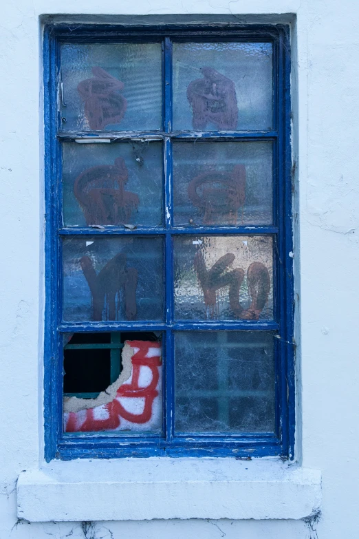 a window with two teddy bears and one shoe sitting on the ledge