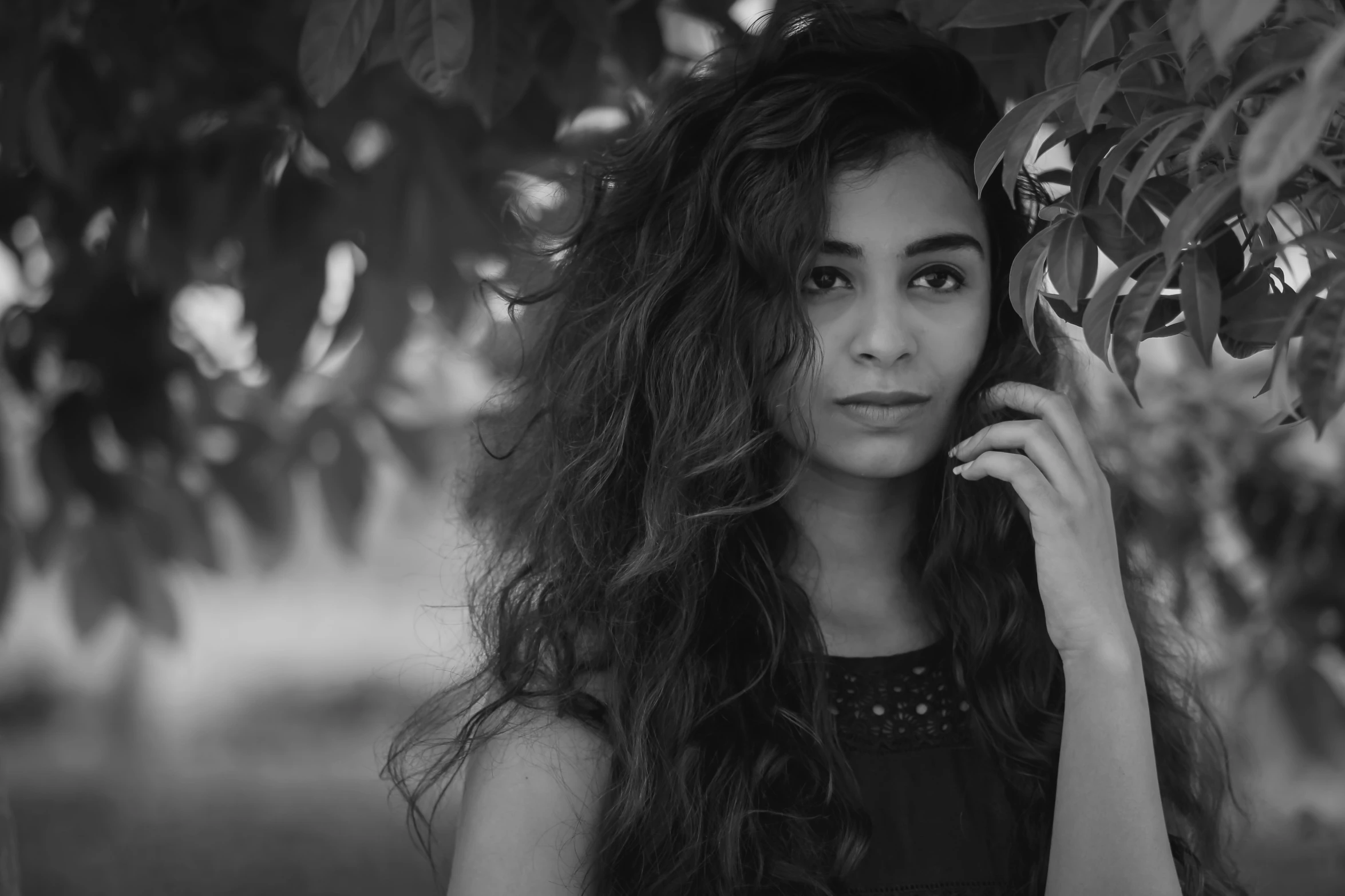 the girl has long curly hair while talking on her cell phone