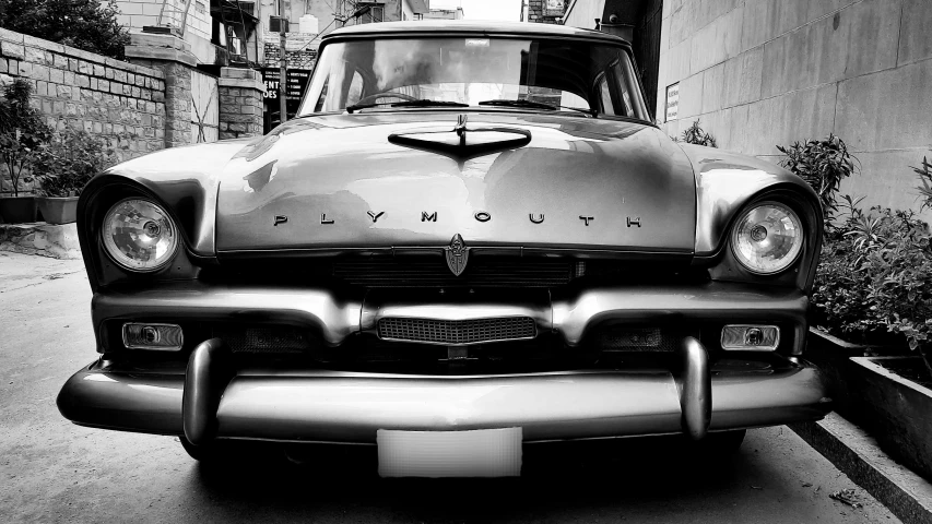 a black and white image of an old classic car