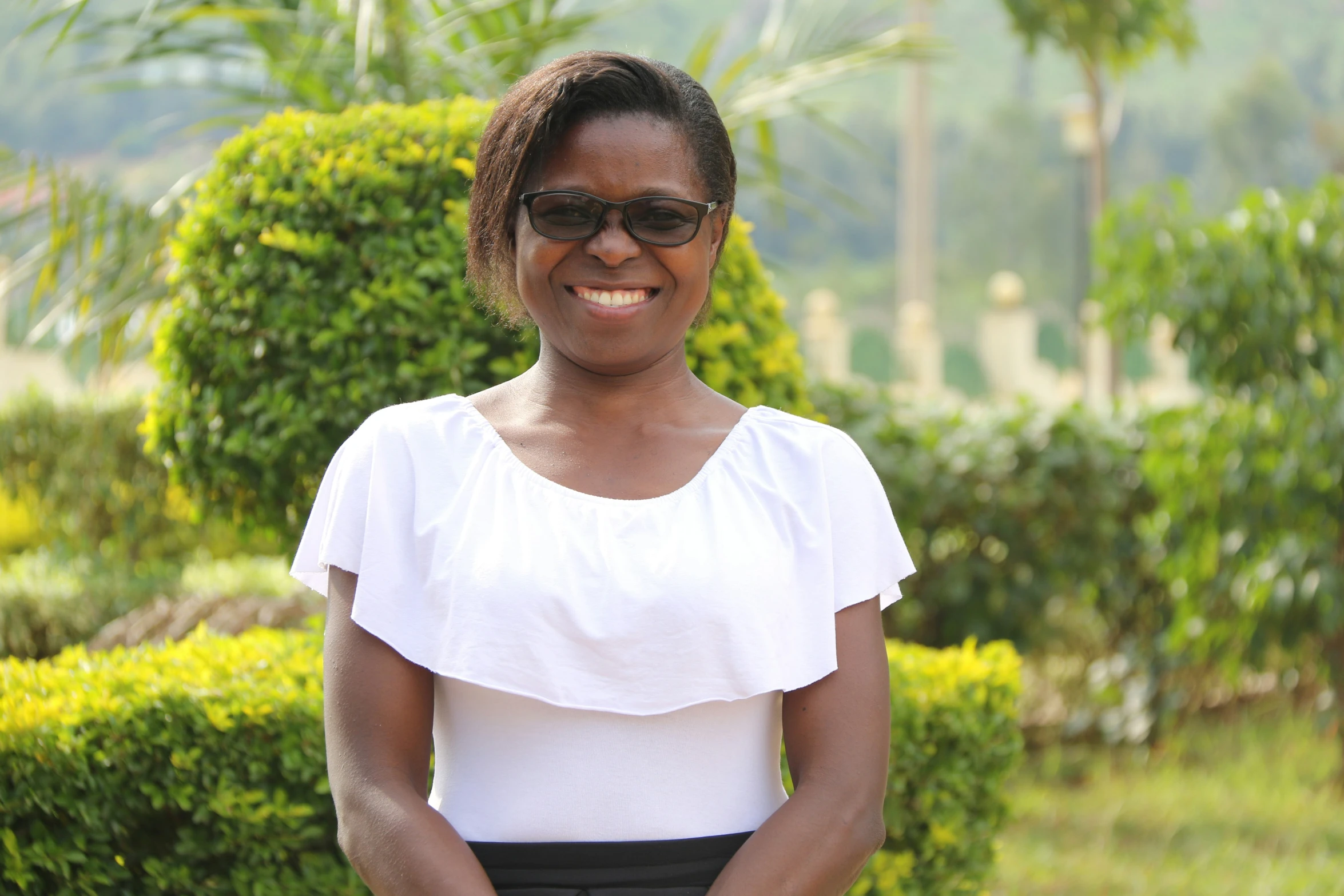 a woman wearing sunglasses standing with her hands in her pockets