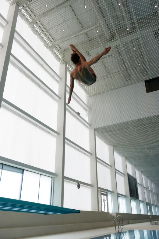 a man dives down from a diving platform