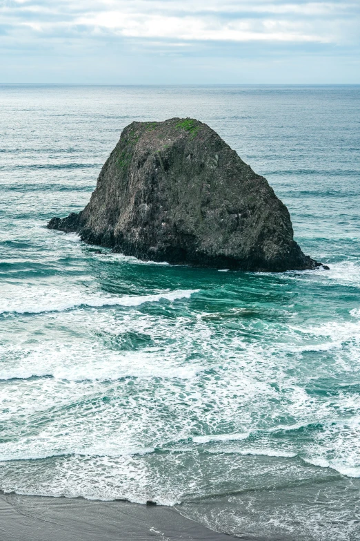 a big rock on the coast in the middle of the ocean