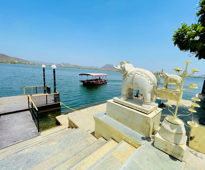 an elephant statue next to boats near the shore