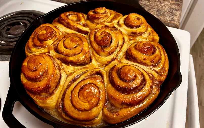 a cast iron set with some cinnamon rolls