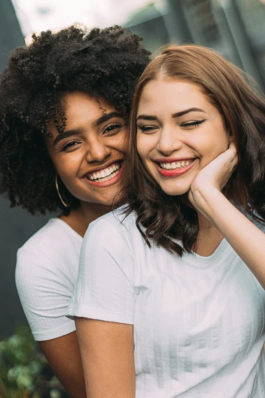 two girls smile as they pose for a picture