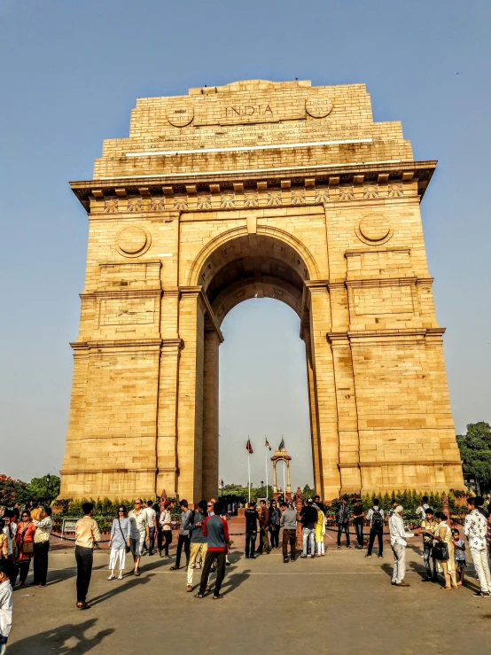 people are standing outside an archway at the top of a hill