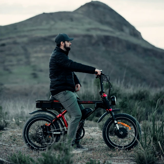 a man standing next to his bike in the middle of the day