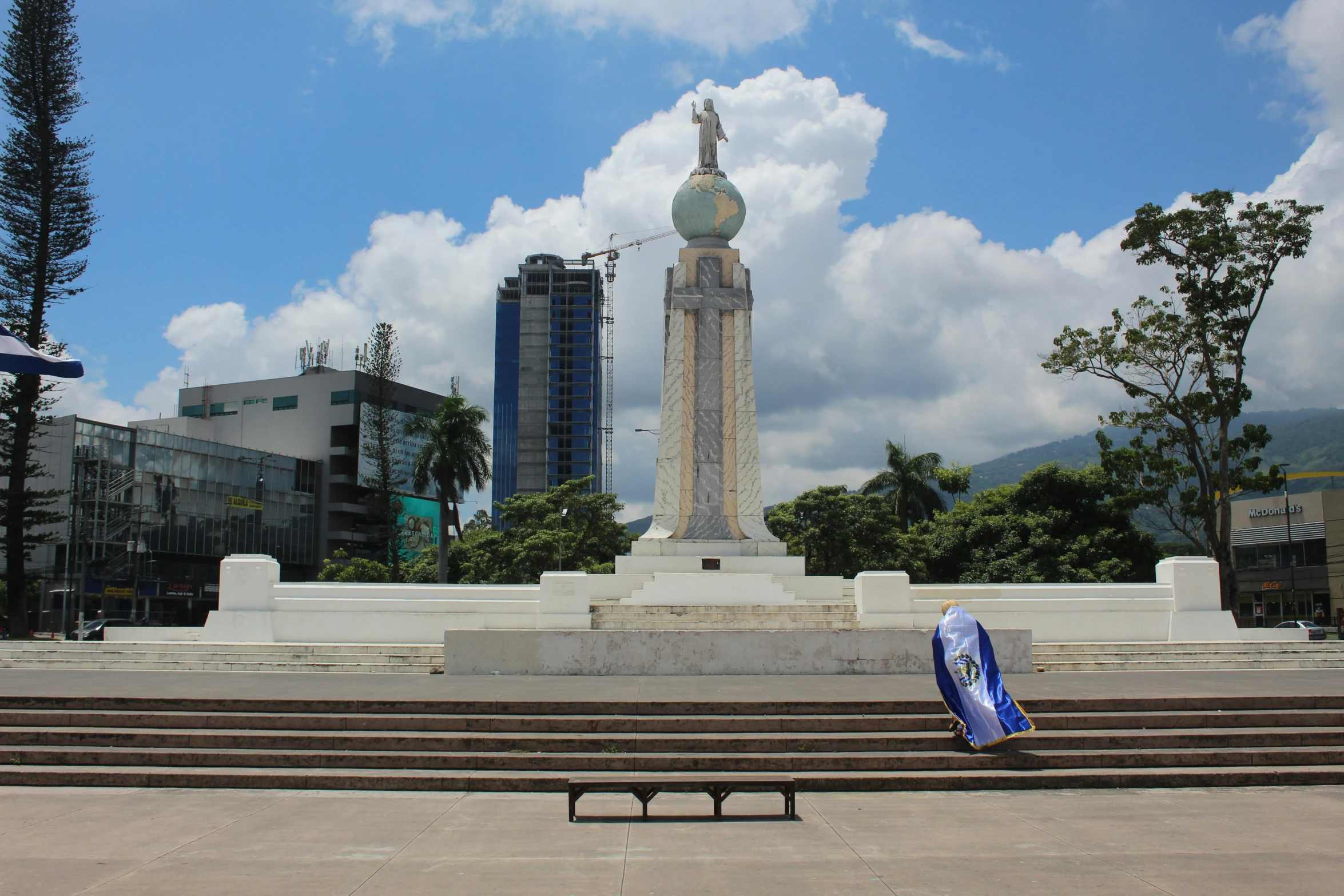 a statue and steps are in a square near a few other buildings