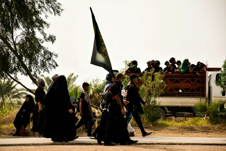 the group of people is walking with a flag