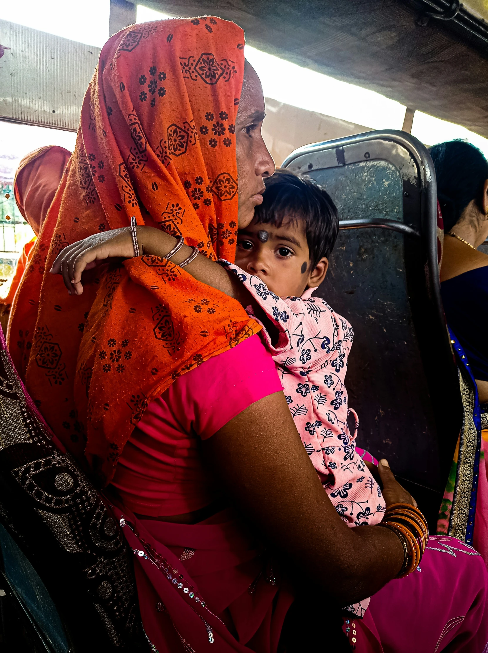 a woman and child sitting together on a bus