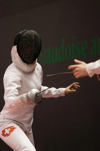 a fencing fencer in white is holding a ball