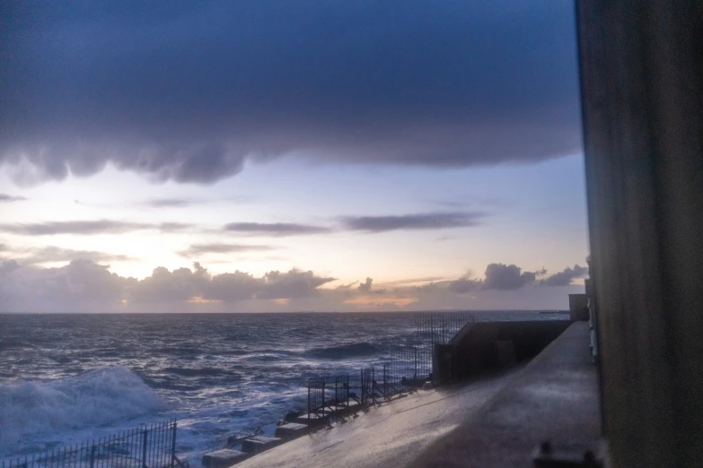 waves crashing onto a beach near some buildings