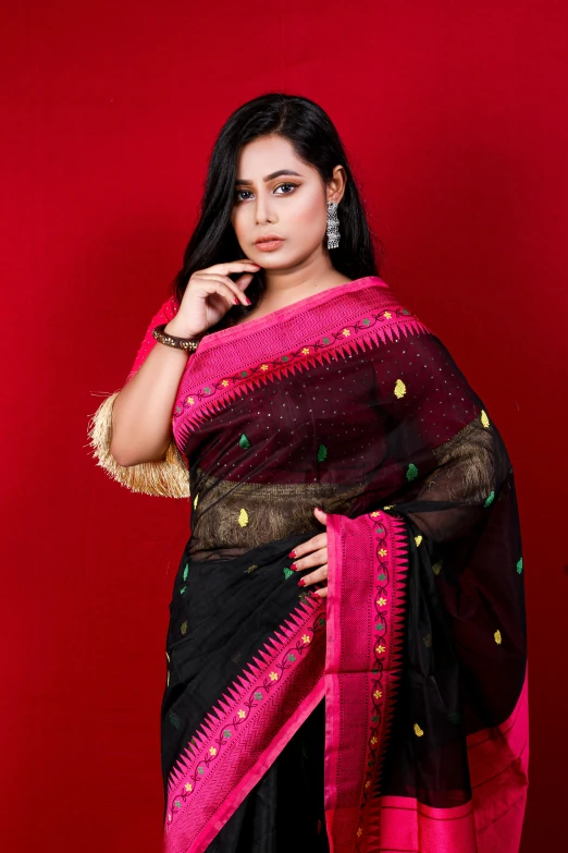 a woman with black and pink sari posing for a picture