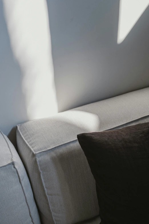 the shadow of a person's foot on a gray couch