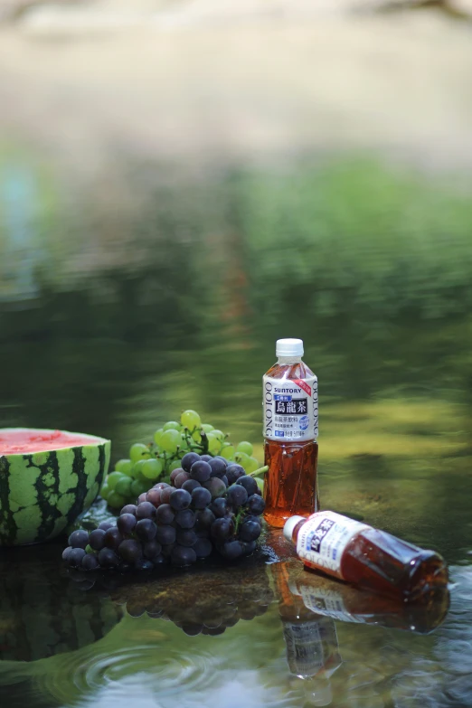 there is watermelon, gs, wine and a bottle of beer on the table