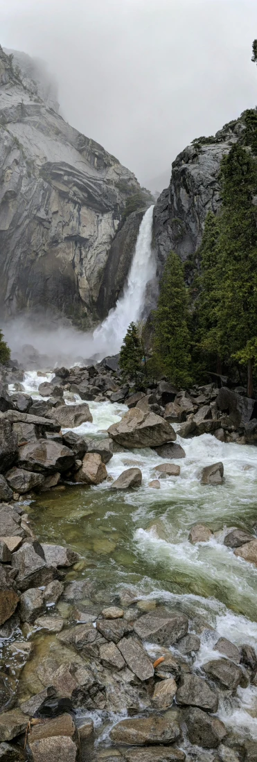 an icy waterfall cascades into a misty river